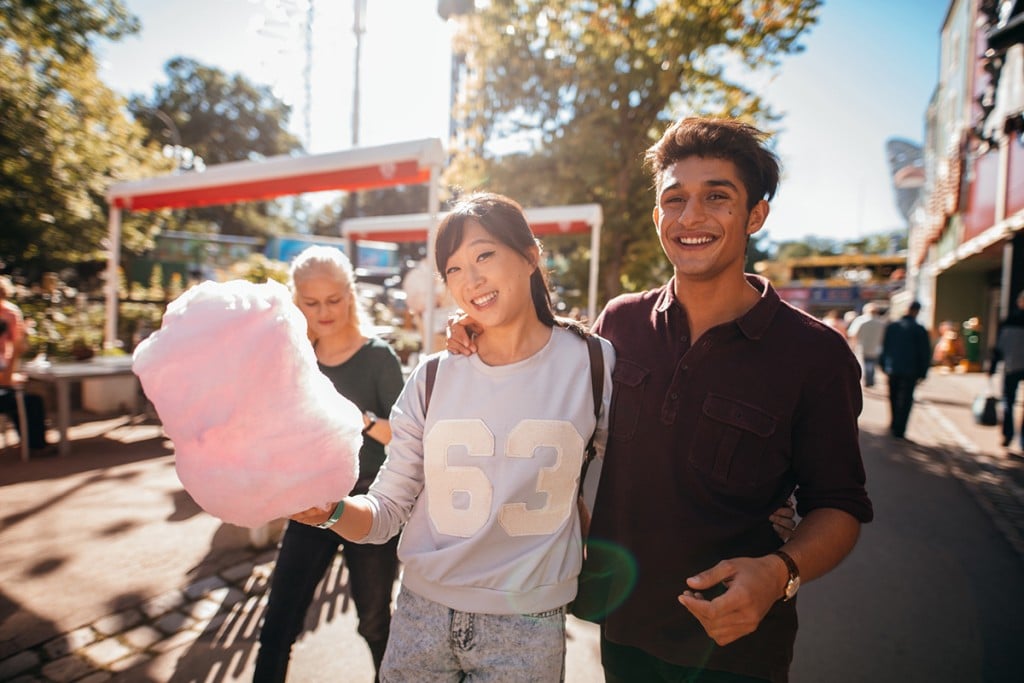 Young People With Cotton Candyfloss At Amusement Park