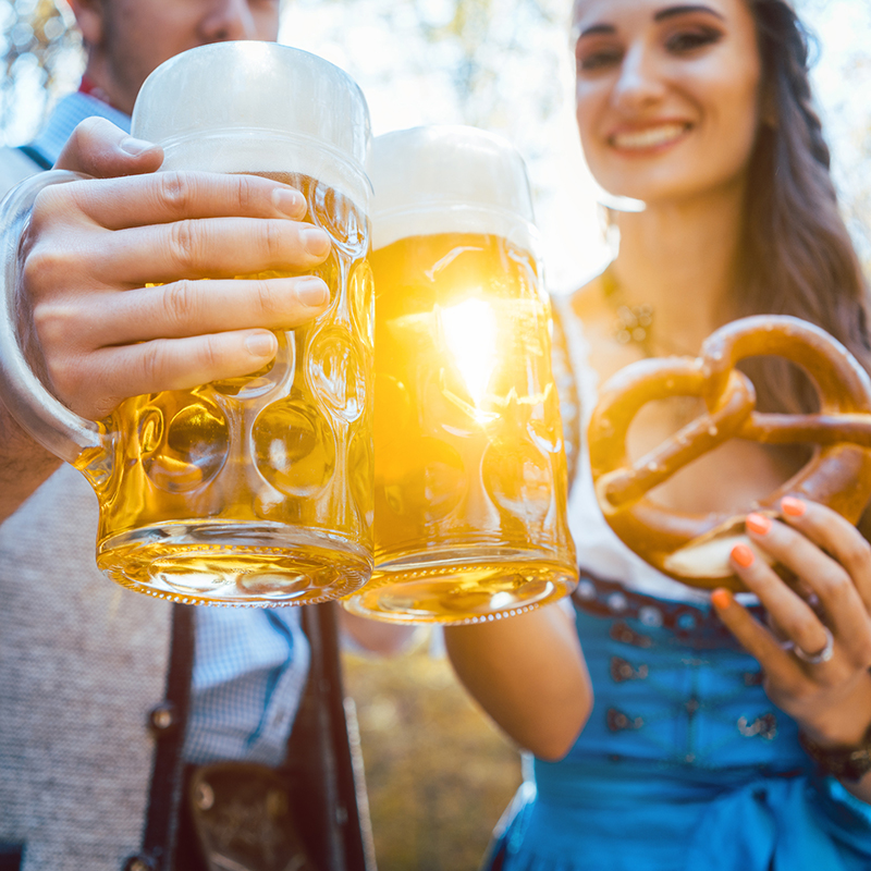 Couple Toasting Beer Glasses While Standing Outdoors