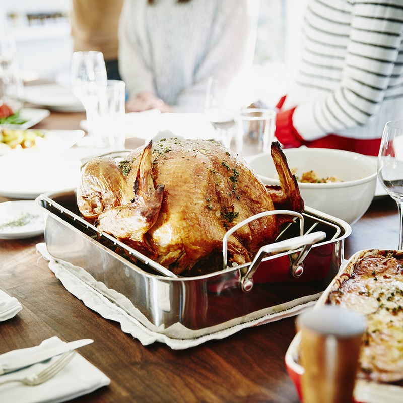 Turkey In Roasting Pan On Table For Holiday Meal