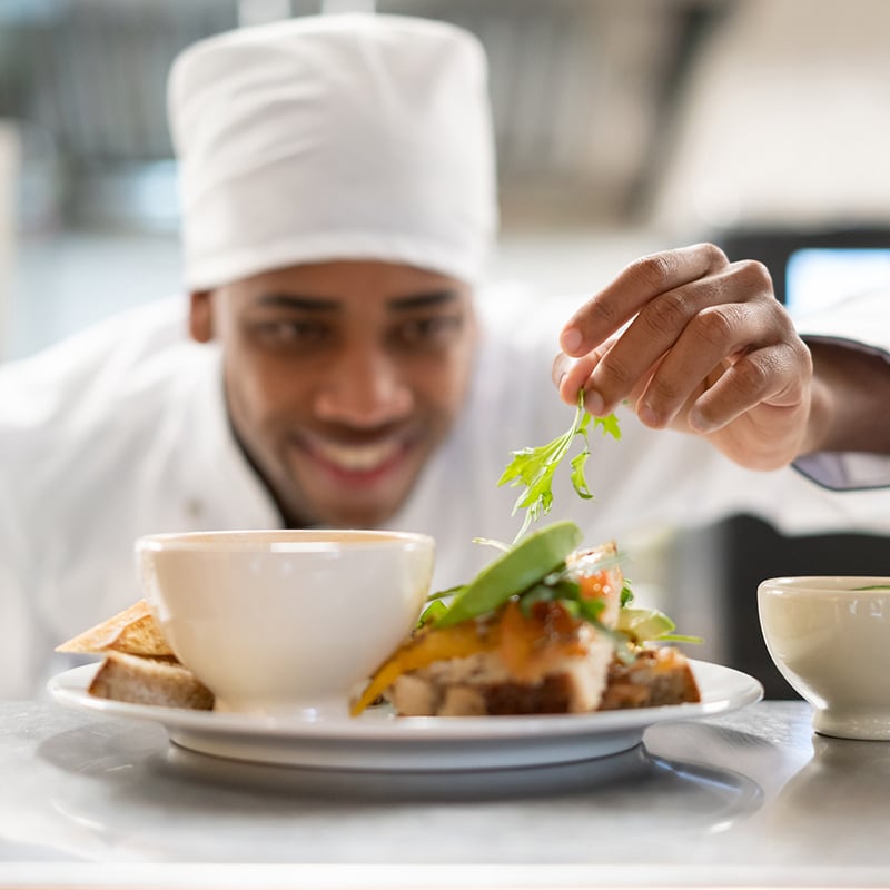 Happy Chef Decorating A Plate While Cooking A Restaurant