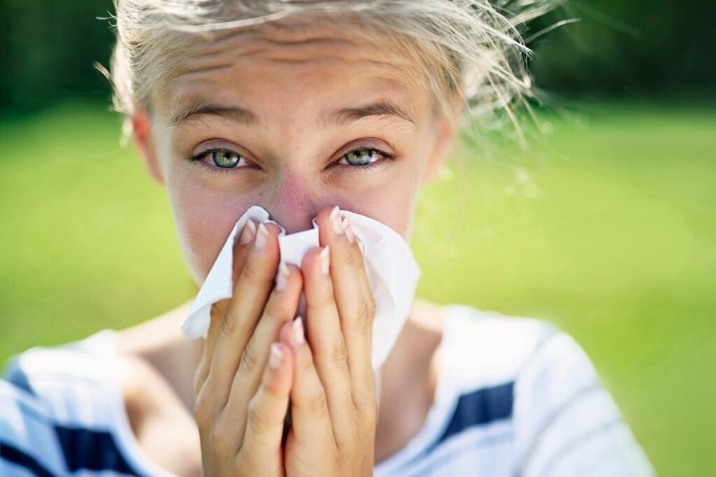 Teenage Girl With Allergy Blowing Nose