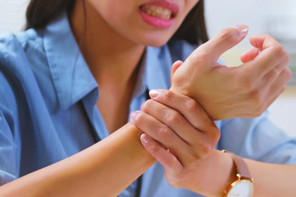 Image of a woman holding her wrist.