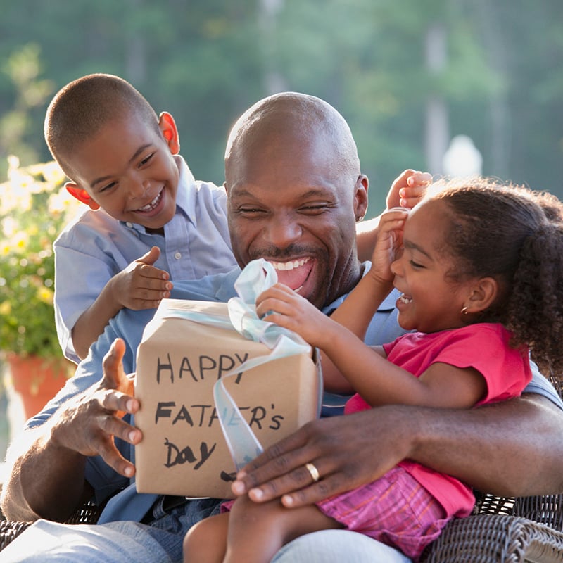 Boy And Girl Watching Father Open Father's Day Gift