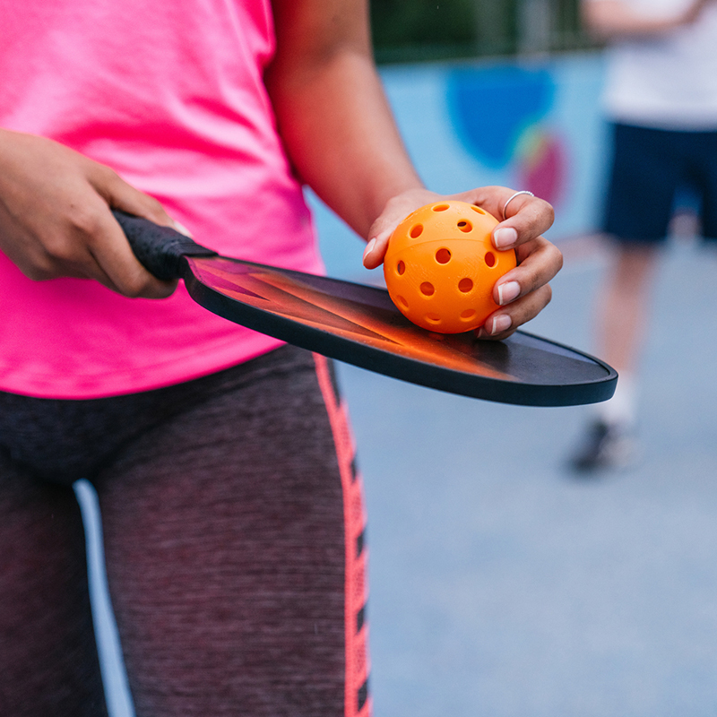 Woman hold a ball against a racket.