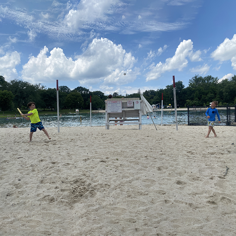 Two children playing wiffle ball.
