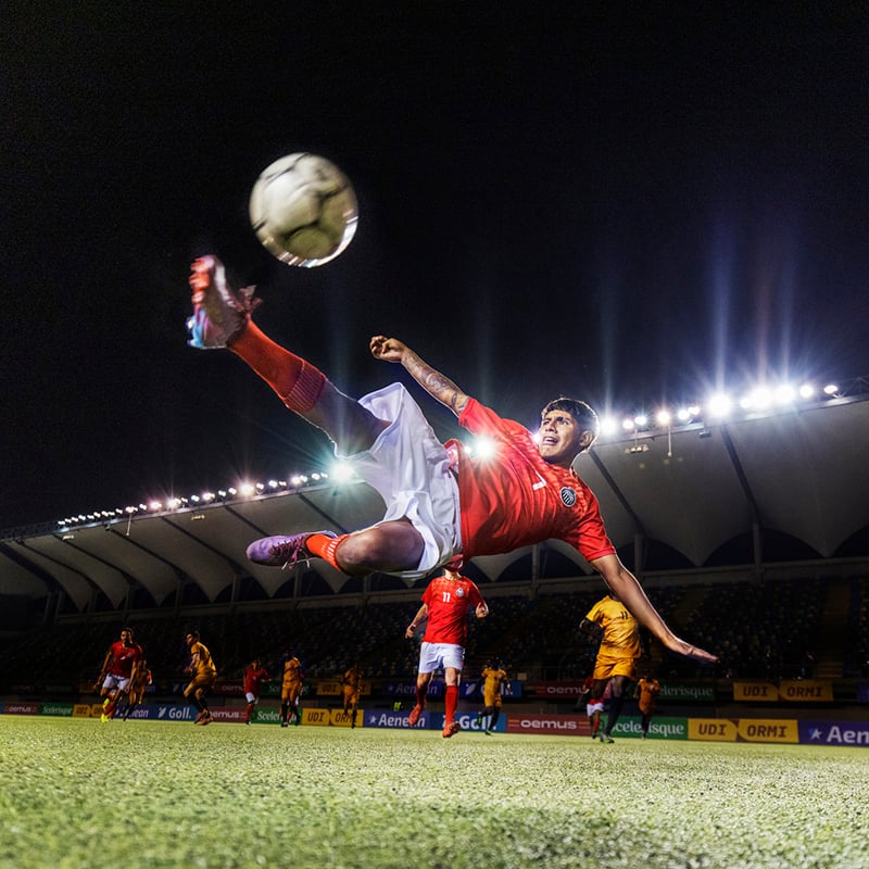 Wide Shot Photo Of Male Athlete Impressively Bicycle Kicking A Soccer Ball While In Mid Air