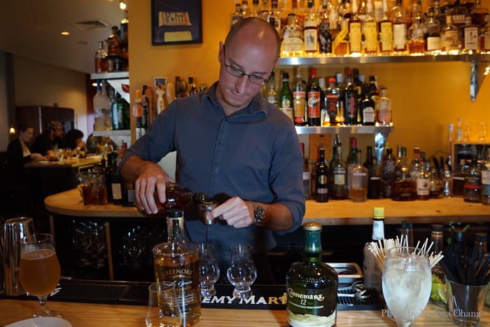 Mike Hall at 12th Avenue Grill pouring whiskey.