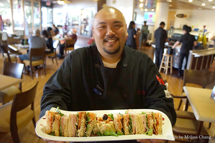 Chef Kyle Kanemura holding a Club sandwich.