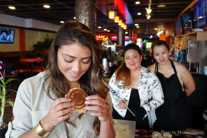 WZ Entertainment owner Tiana Haraguchi getting a bite of her first Whatchafillin' in her arcade.