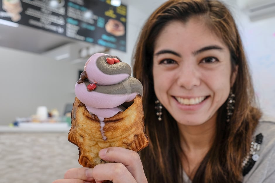 Kelli with a taiyaki fish cone with ube and chocolate ice cream swirled in it.