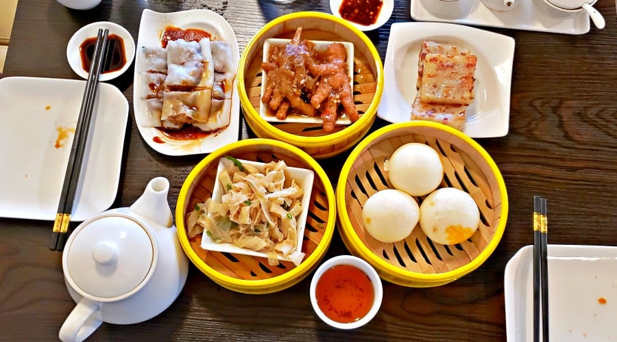 array of plates holding a multitude of dim sum is spread across a tabletop