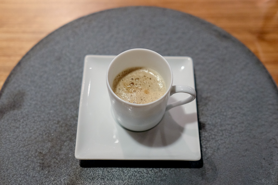 A small cup of corn soup frothed to look like a cup of espresso