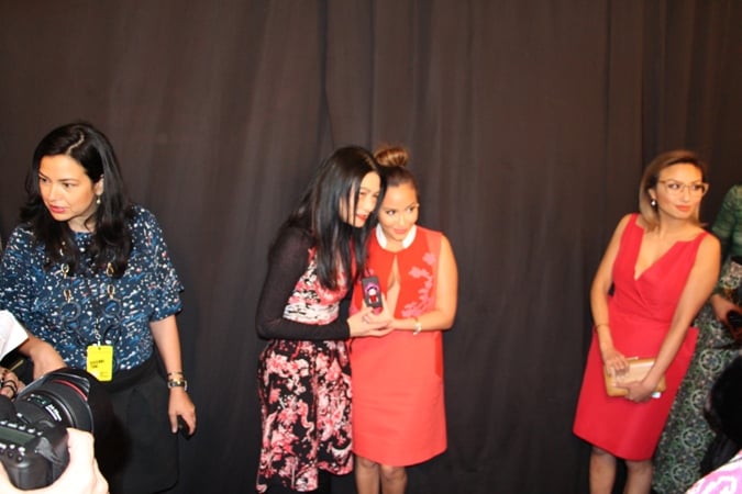 Vivienne Tam presents Adrienne Bailon with a gift backstage before the show.