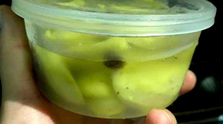 container of pale green pkckled mango