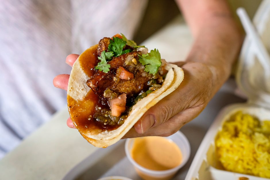 Salt and pepper pork belly taco in hand