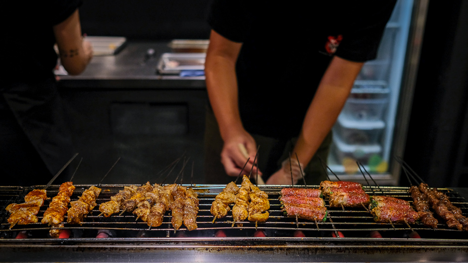 Skewers of meat being grilled at Honolulu Skewer House