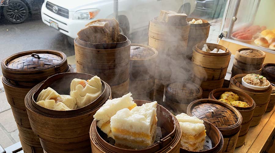 stacks of steamers hold plump morsels of dim sum in a shop window