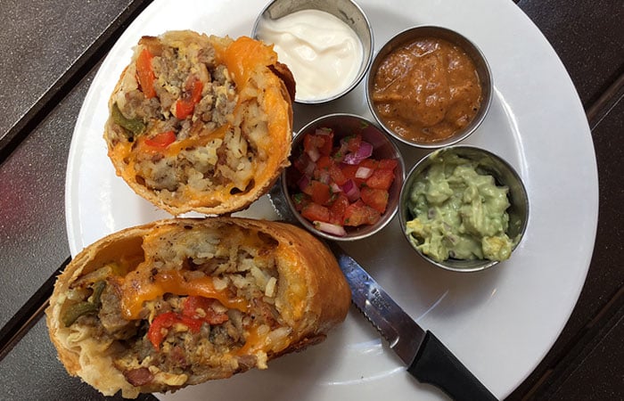 The BrunCHonga ($13) comprises a deep fried, large burrito stuffed with sausage, bacon, scrambled eggs, hash browns and cheese. It’s served with fresh guac, sour cream and roasted tomato salsa.