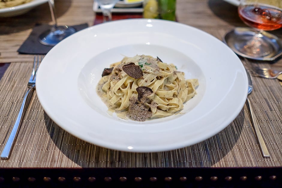 plate of mushroom fettuccine pasta with black truffle shavings