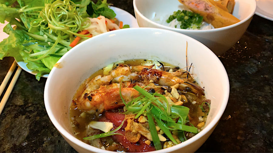vibrant bowls of grilled pork and shrimp, rice vermicelli noodles and fresh herbs waiting to be mixed together