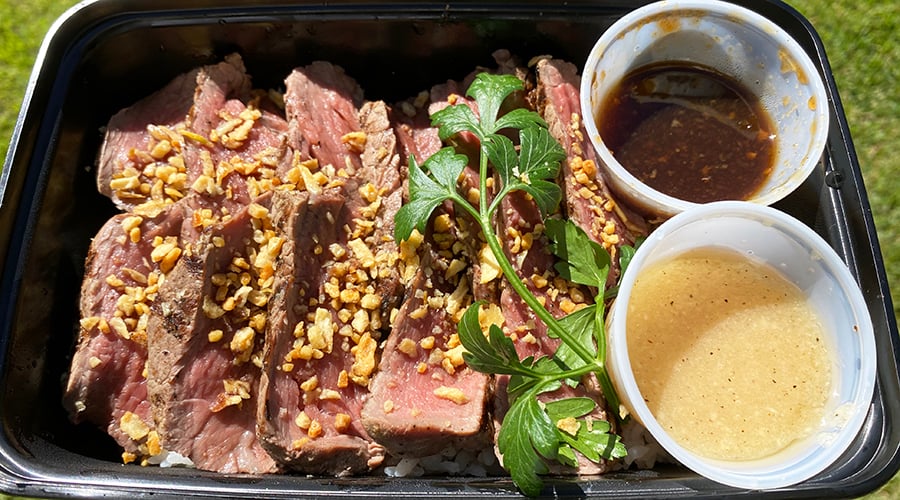 tenderloin strips fanned out on rice with fried garlic chips and zesty, garlicky dipping sauces