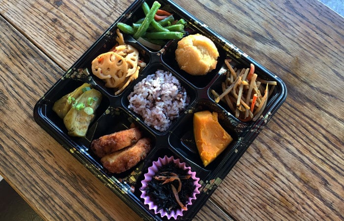 The vegetable bento consists of: eggplant, tofu patty, seaweed, kabocha, Gobo, string beans, lotus root, red bean mochi rice and a mini andagi.
