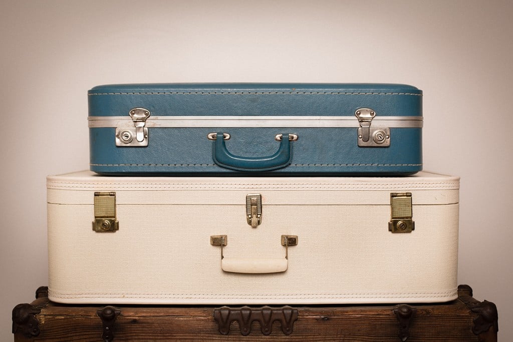 Two Retro Suitcases Stacked On Wood Trunk
