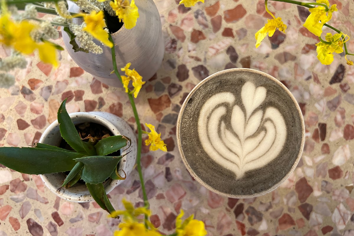 Latte art coffee on wooden table, cozy image for marketing