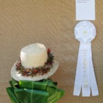 lei on straw hat with prize ribbon