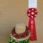 lei on straw hat with prize ribbon