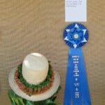 lei on straw hat with prize ribbon