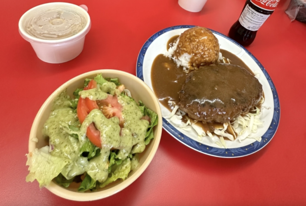plates of green salad and Hamburger Steak covered with brown gravy