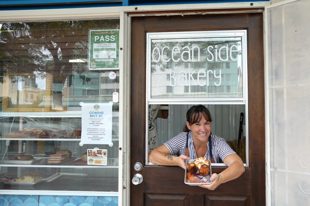 woman leaning out of window with pastries