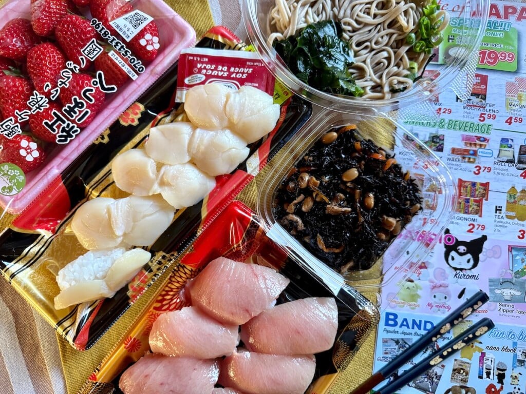 assortment of fresh Strawberries and takeout sushi