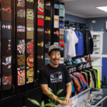 man standing in front of t-shirt wall display