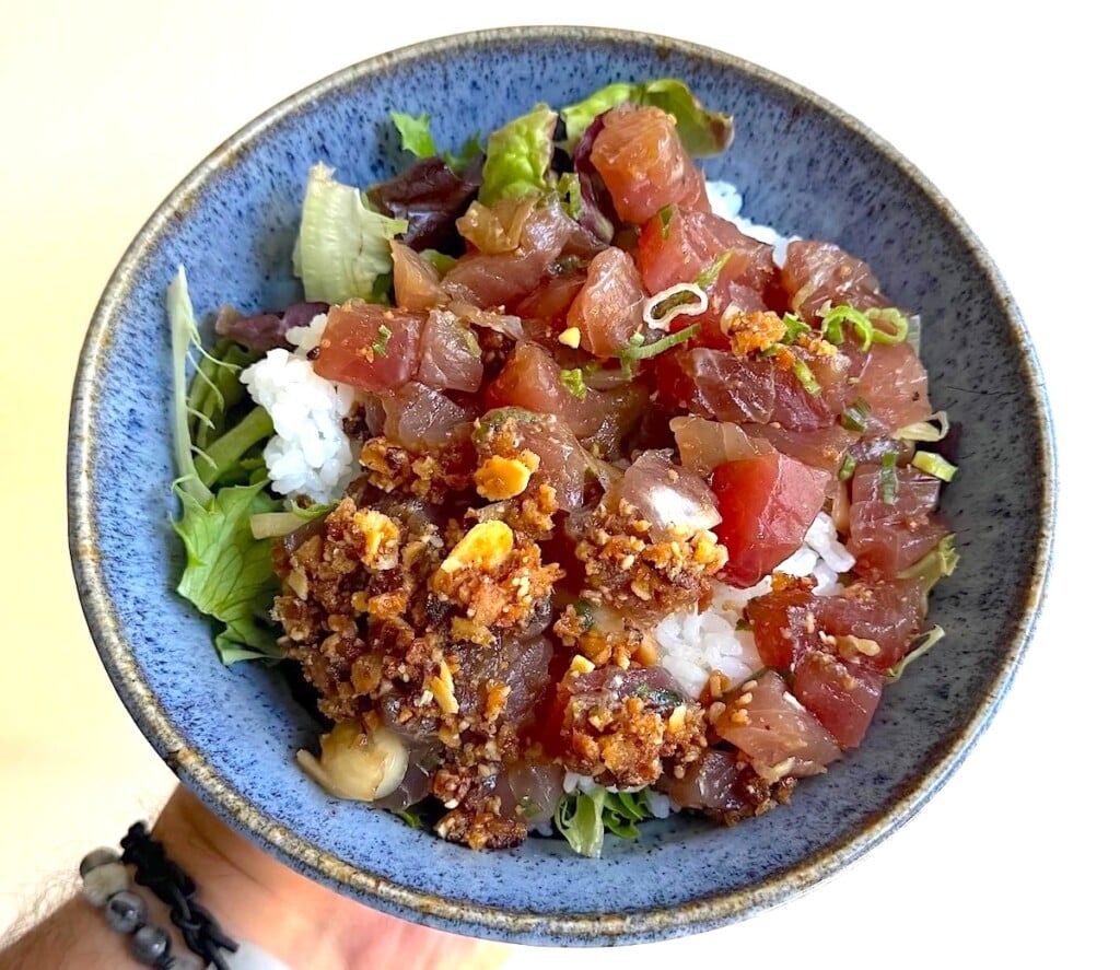 hand holding blue bowl of Ahi Poke