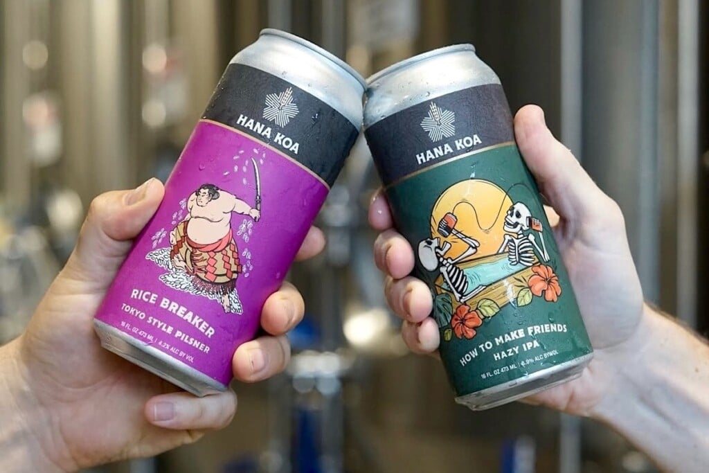 two colorful beer cans held up in a toast