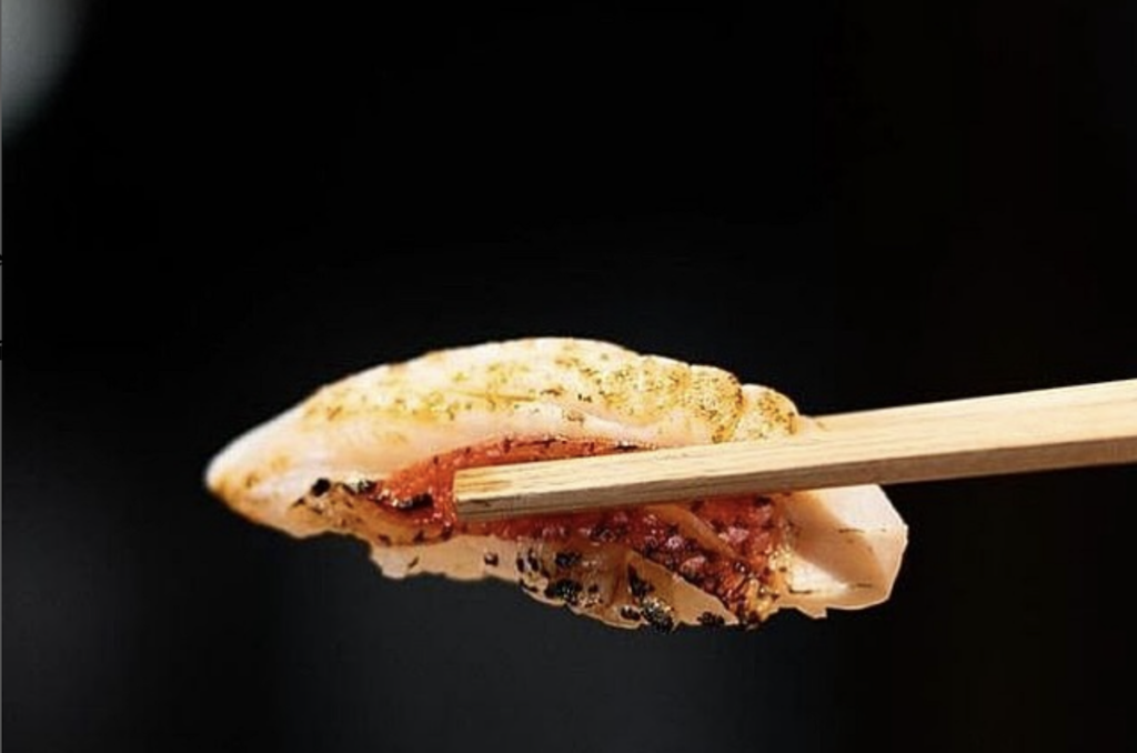 chopsticks hold a piece of nigiri Sushi