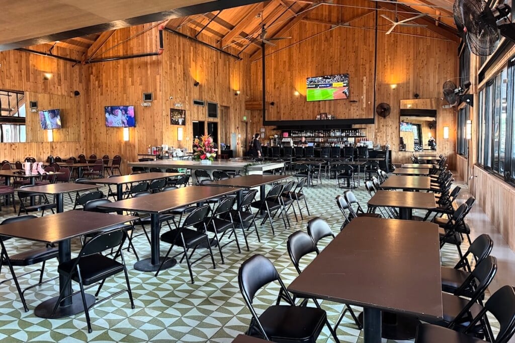 large dining room with high ceilings and tv screens
