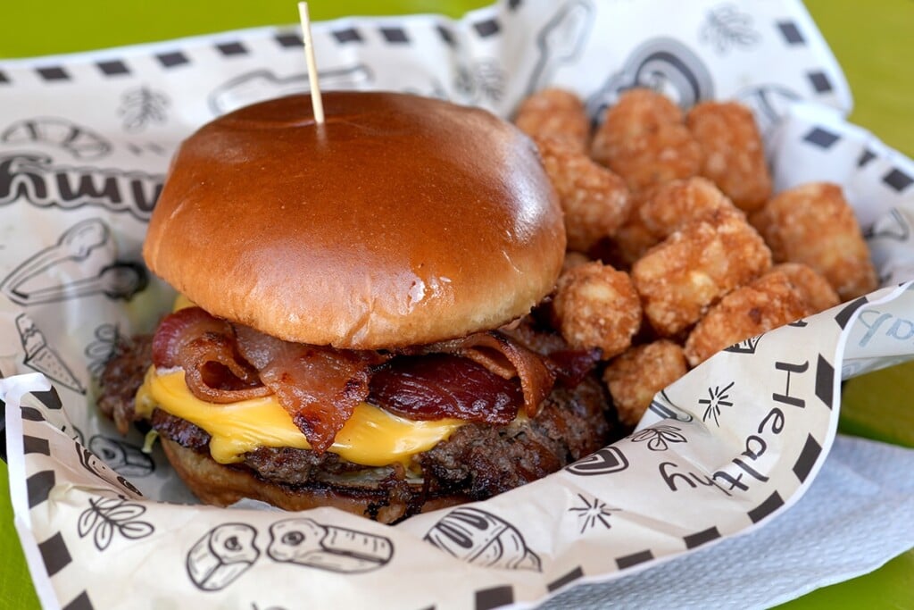 closeup of loaded smash burger and tater tots