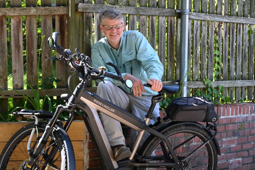 Dr. Gregory Maassen posing with e-bike in promotion of his 5,800-mile e-bike journey across the U.S.