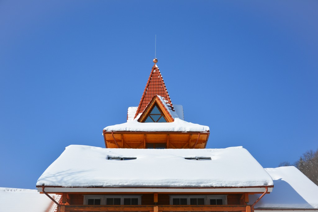 Snow,on,the,roof,of,wooden,house.,attic,window,of