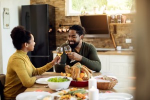 Happy African American Couple Toasting During Thanksgiving Meal In Dining Room.