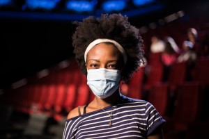 Portrait Of A Young African American Woman With A Protective Mask At The Cinema