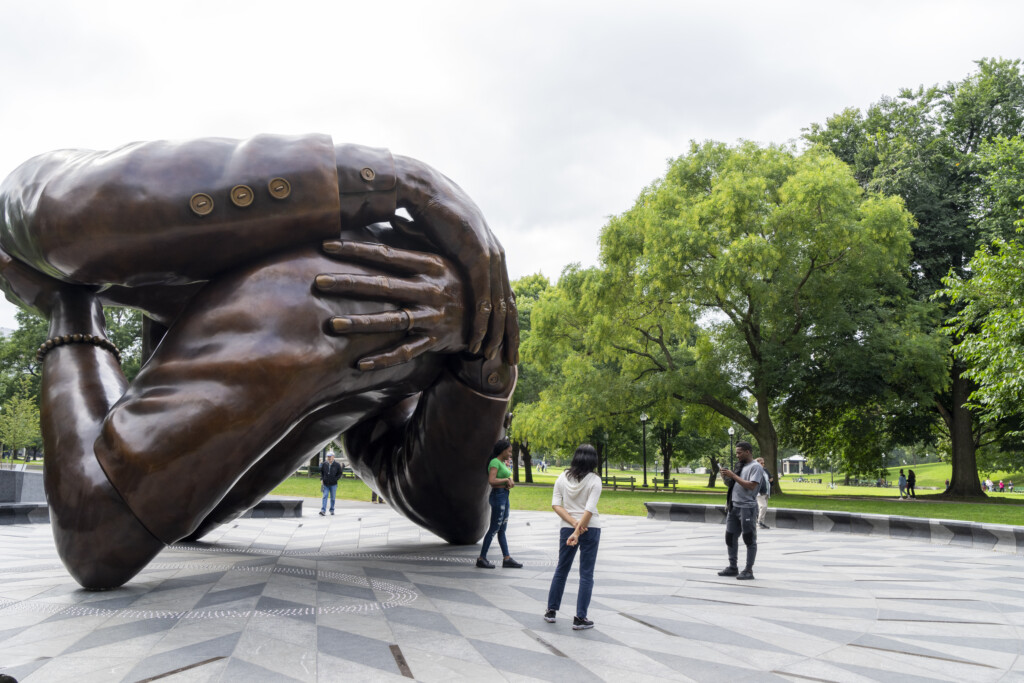 The Embrace Sculpture With Tourist Around It.