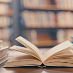 Library, Books On Table And Background For Studying, Learning And Research In Education, School Or College. Reading, Philosophy And Open, Vintage Or History Print Book, University Blurred Background
