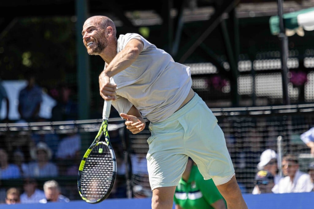 Tennis play Adrian Mannarino pictured on the court with a tennis racket.