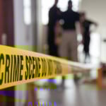 Crime Scene Tape In Building With Blurred Forensic Team