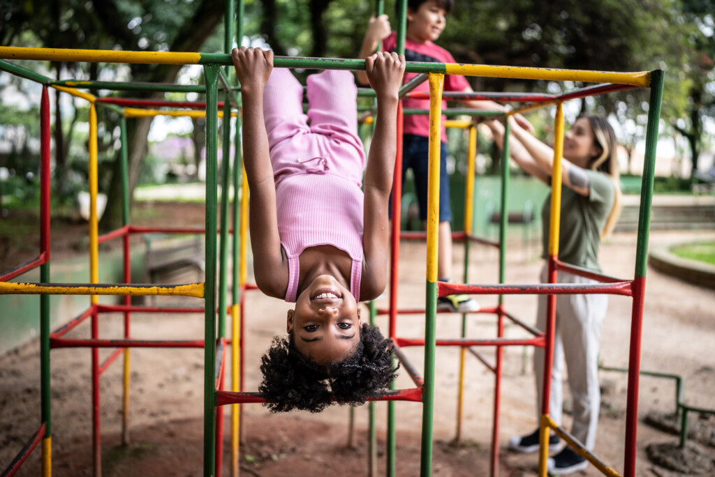 Portrait Of A Girl Upside Down In A Jungle Gym In A Park