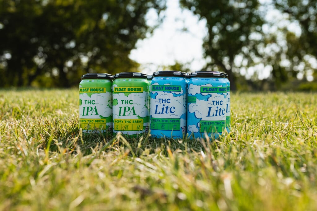 Two six packs of THC-infused cans in the grass.